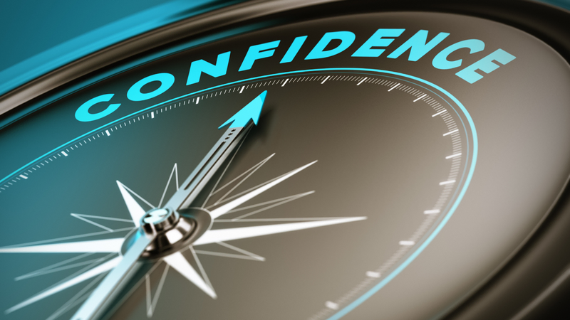 A close-up of a compass with the word confidence in bold blue letters, symbolizing trust and reliability in dock construction services.
