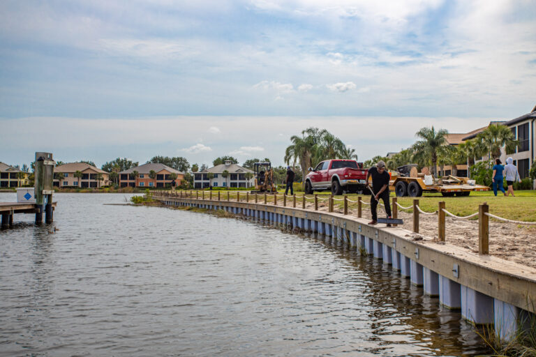 a group of people on a dock by a body of water