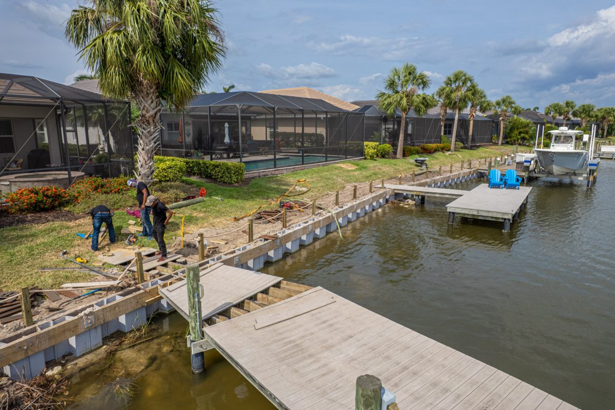 a group of people working on a dock near a body of water